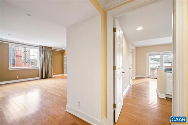 a view of a hallway with wooden floor and windows
