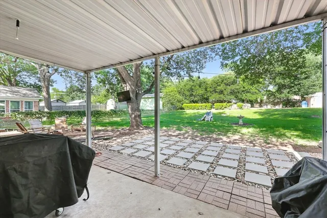 a view of a patio with a table and chairs under an umbrella