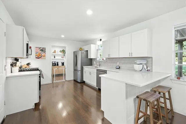 a kitchen with stainless steel appliances kitchen island a sink a stove a refrigerator and cabinets