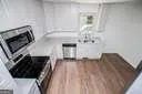 a kitchen with granite countertop white cabinets and a stove