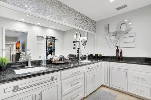 a bathroom with double vanity sinks a vanity and a mirror