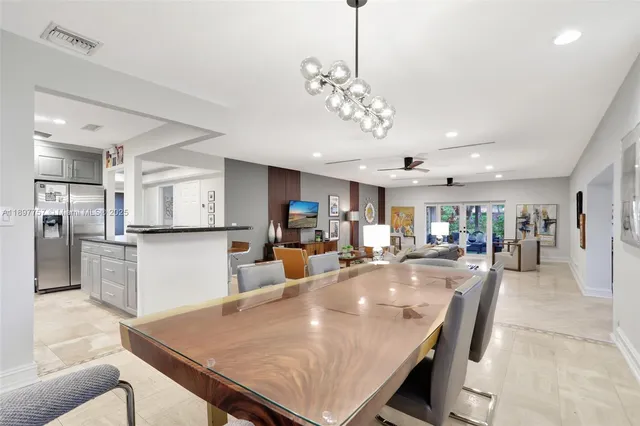 a view of a dining room and livingroom with furniture wooden floor a chandelier