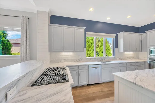 a large kitchen with kitchen island a sink stainless steel appliances and cabinets