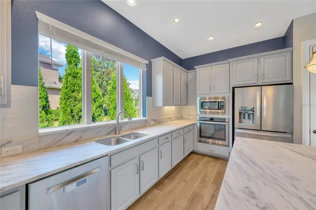 a large kitchen with kitchen island granite countertop a large counter top stainless steel appliances and cabinets