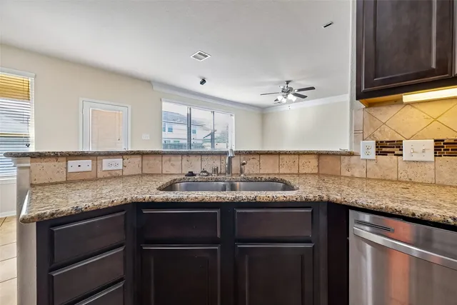 a kitchen with a granite countertop sink cabinets and window