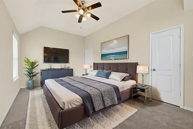 a bedroom with a large bed and a flat screen tv