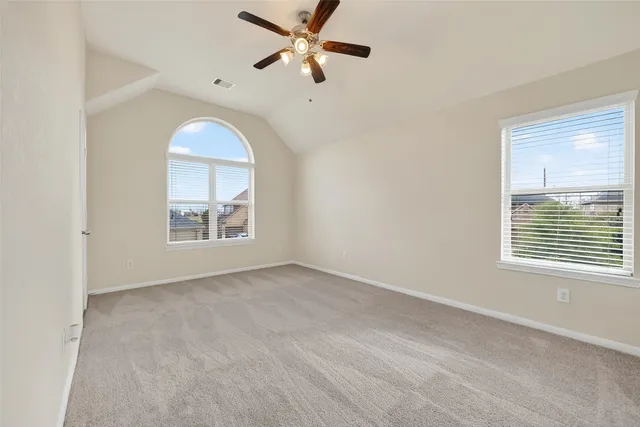 an empty room with windows and fan