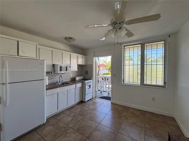 a kitchen with refrigerator and cabinets