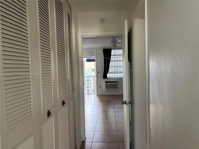 a view of a hallway with wooden floor and a bathroom