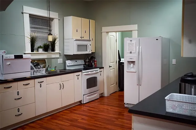 a kitchen with granite countertop white cabinets and white appliances