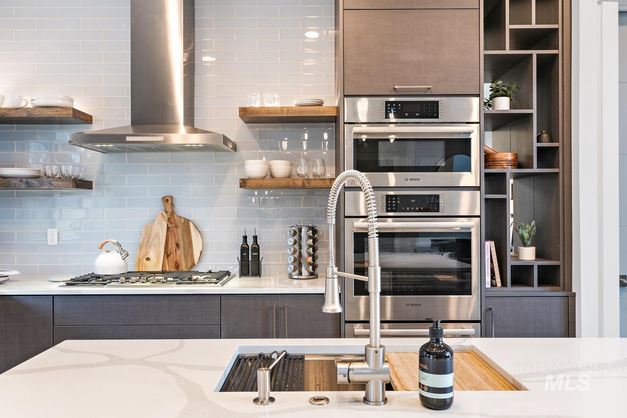599 West Warren Street Boise, ID 83706 - Photo 16 of 41 Gourmet kitchen featuring a stainless steel gas range with a matching range hood, light blue subway tile backsplash, and dark wood-finish cabinetry