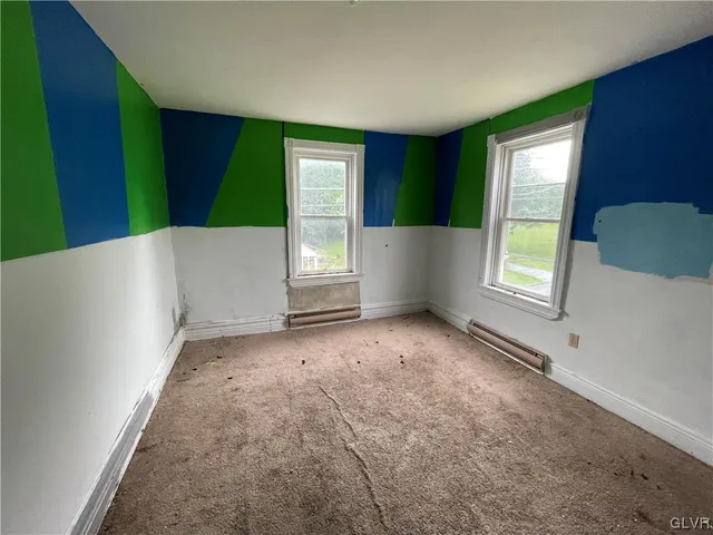 a view of an empty room with window and stairs