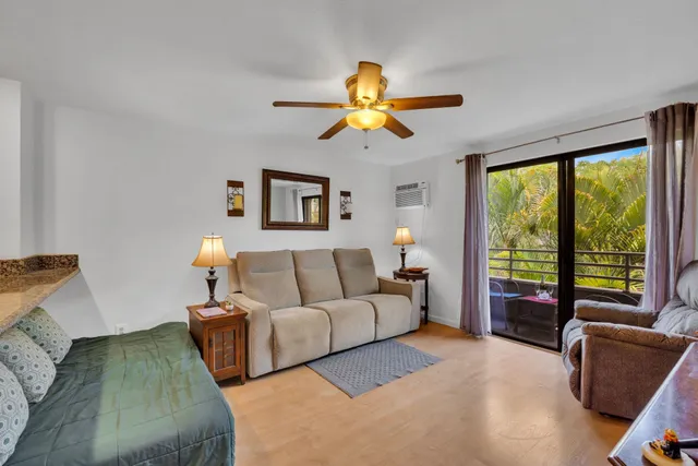 a living room with furniture kitchen view and a chandelier