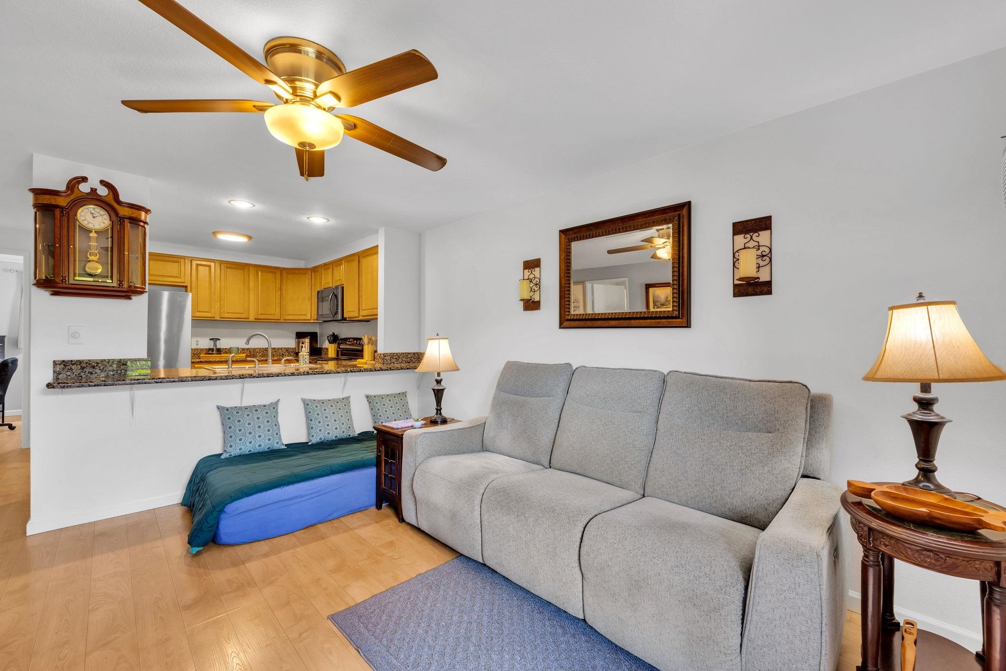 2747 South Kihei Road, Unit C205 Kihei, HI 96753 - Photo 4 of 49 a living room with furniture and a flat screen tv with kitchen view