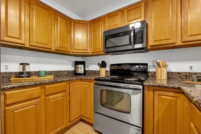 a kitchen with granite countertop cabinets stainless steel appliances granite countertop white cabinets granite counter tops and a window