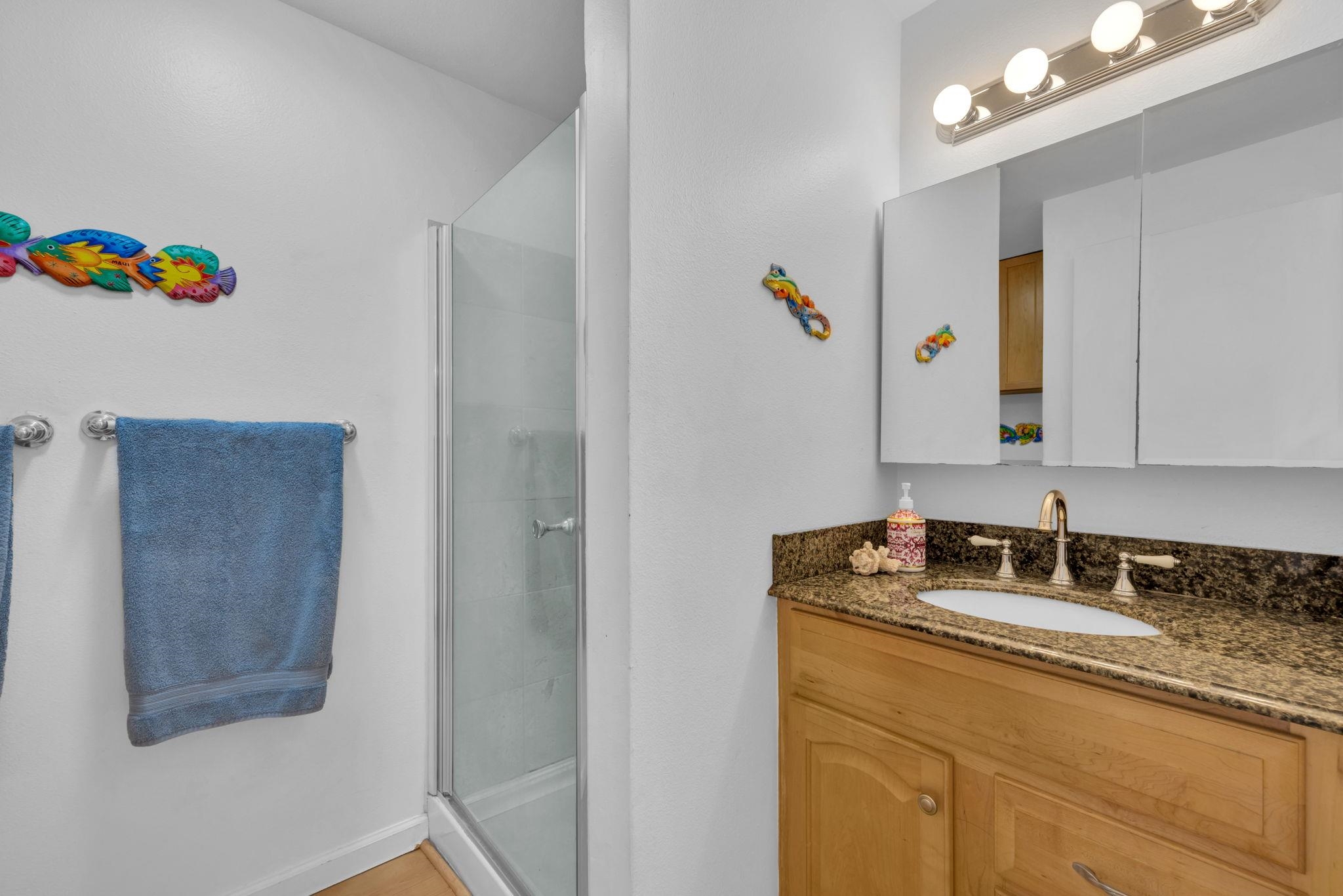 2747 South Kihei Road, Unit C205 Kihei, HI 96753 - Photo 9 of 49 a bathroom with a granite countertop sink a mirror and shower