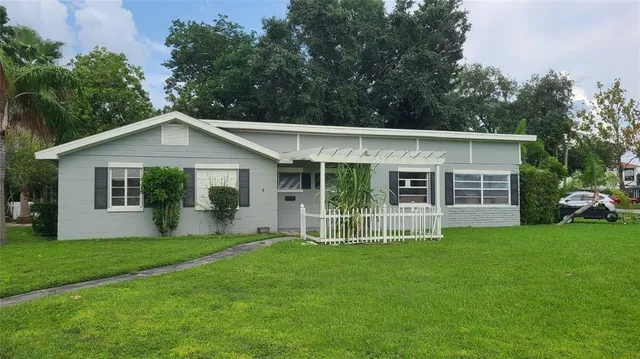 a front view of a house with a yard and green space