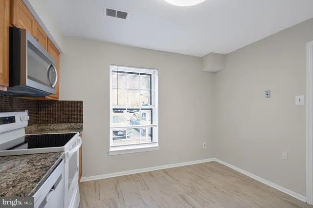 a kitchen with granite countertop a sink a stove and oven