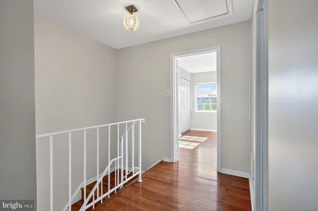 a view of a hallway with wooden floor and staircase