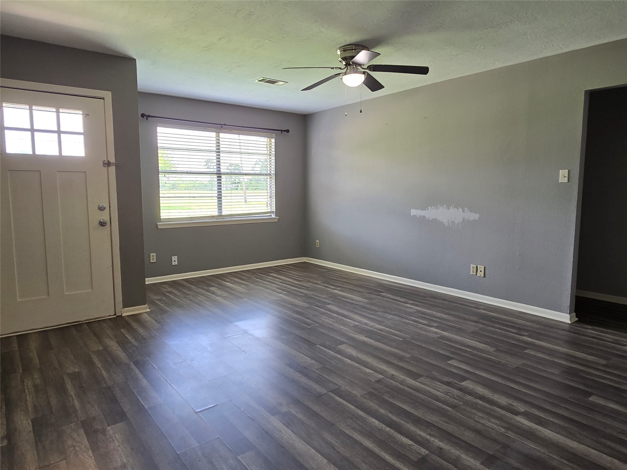 17415 Fir Road Alvin, TX 77511 - Photo 3 of 16 an empty room with wooden floor chandelier fan and windows