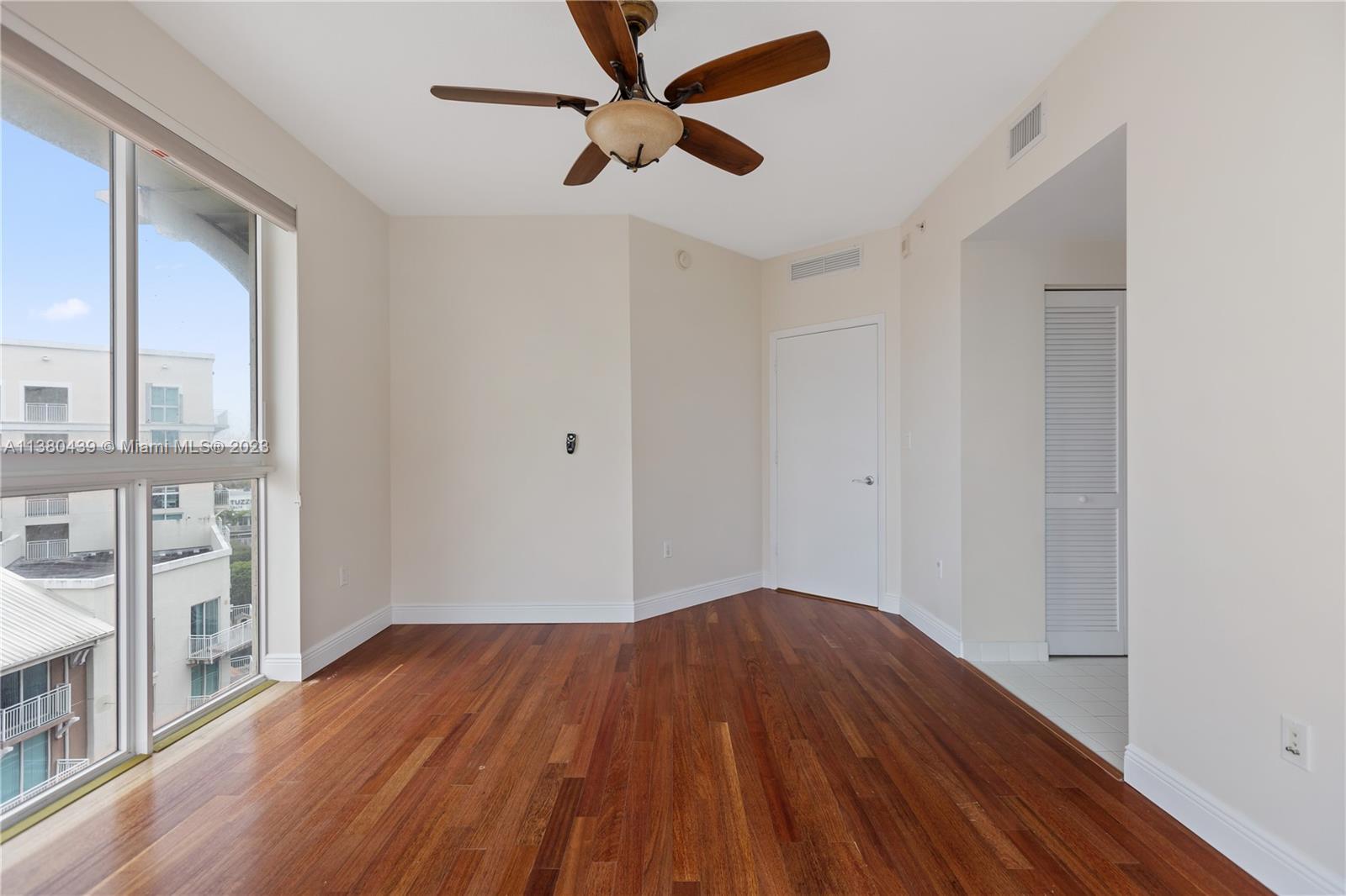 7290 Southwest 90th Street, Unit F606 Miami, FL 33156 - Photo 13 of 17 a view of empty room with wooden floor and fan