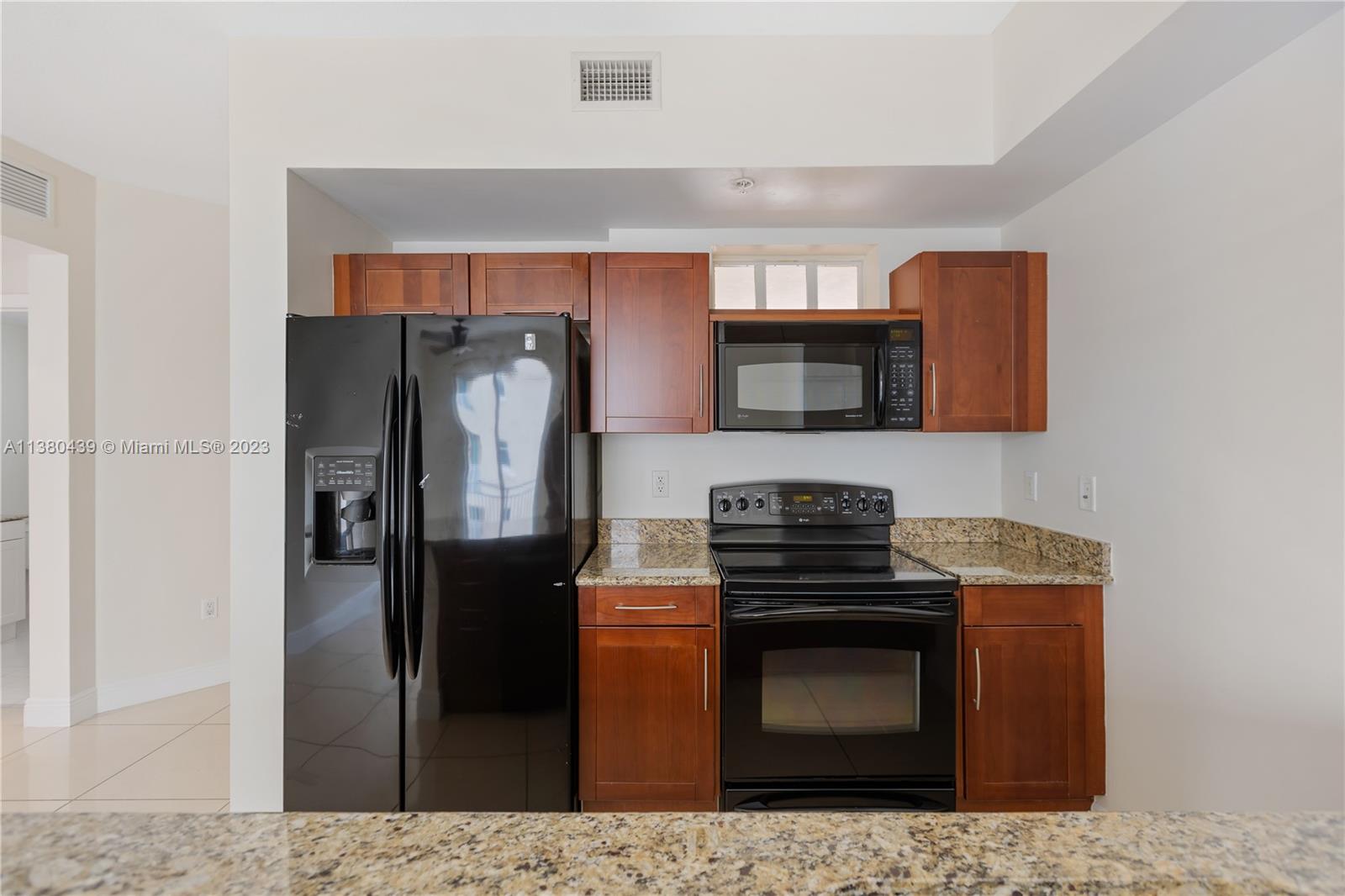 7290 Southwest 90th Street, Unit F606 Miami, FL 33156 - Photo 3 of 17 a kitchen with stainless steel appliances granite countertop a refrigerator a stove and a sink