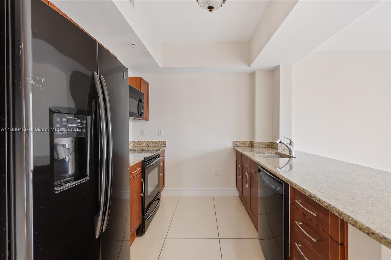 7290 Southwest 90th Street, Unit F606 Miami, FL 33156 - Photo 4 of 17 a kitchen with stainless steel appliances granite countertop a refrigerator and a sink