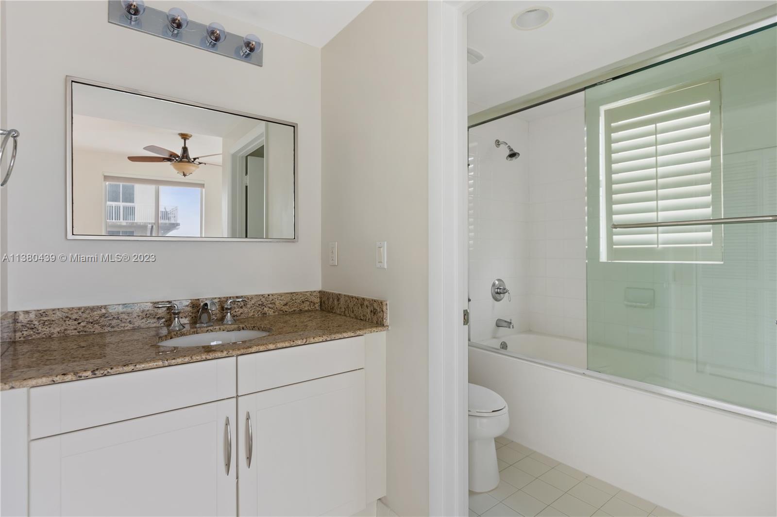7290 Southwest 90th Street, Unit F606 Miami, FL 33156 - Photo 8 of 17 a bathroom with a granite countertop sink a toilet and shower