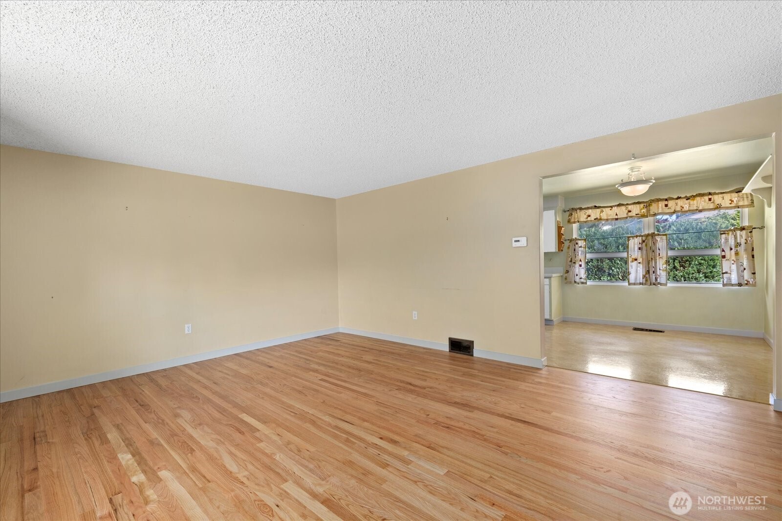 9125 Meadow Way Everett, WA 98208 - Photo 17 of 27 an empty room with wooden floor and windows