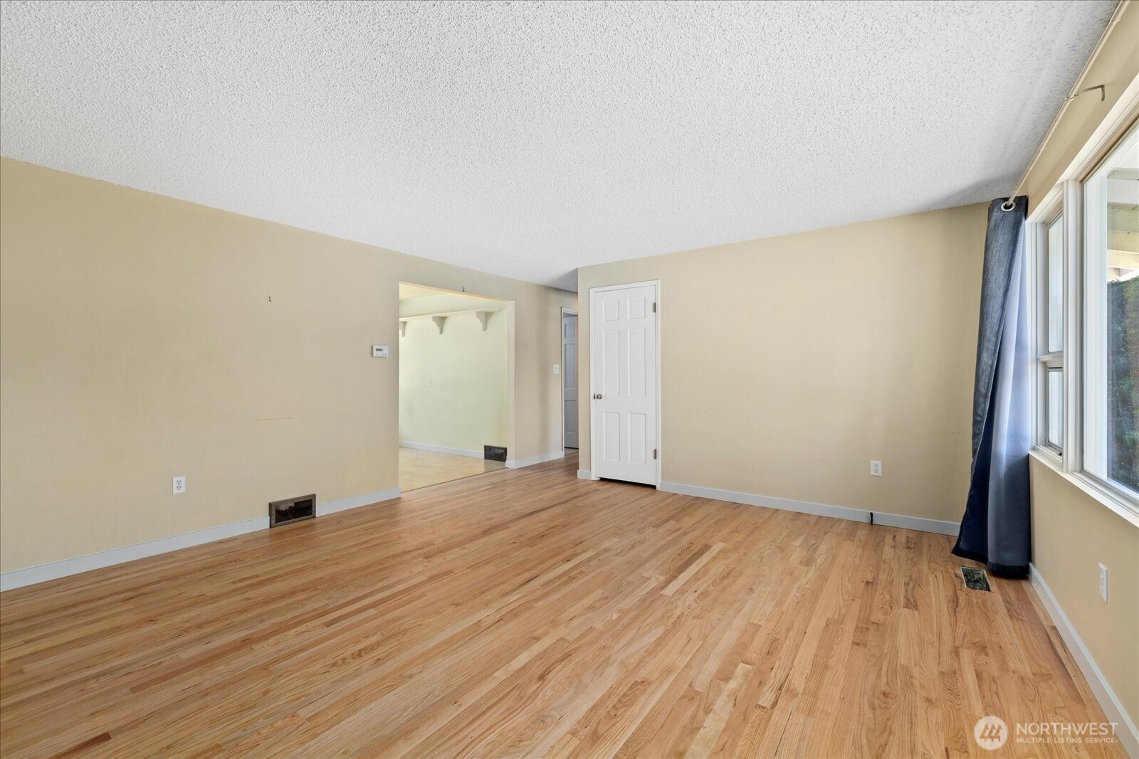 9125 Meadow Way Everett, WA 98208 - Photo 6 of 27 a view of an empty room with wooden floor and a window