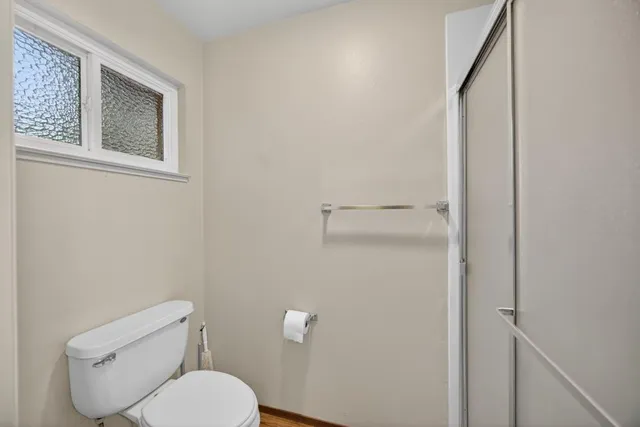 a view of an empty room with wooden floor and a floor to ceiling window