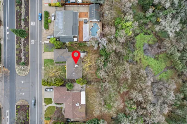 an aerial view of residential houses with outdoor space and trees