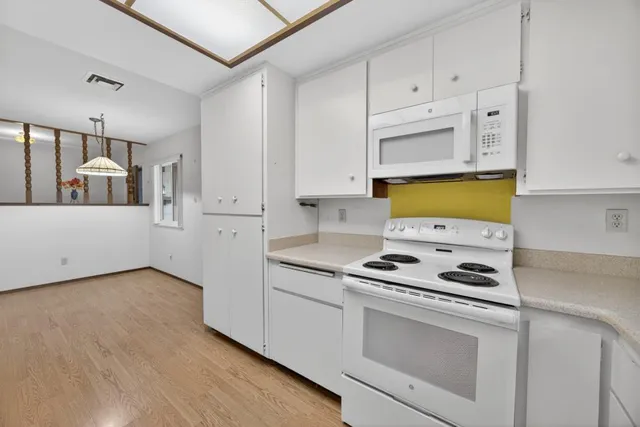 a view of a room with wooden floor and entryway