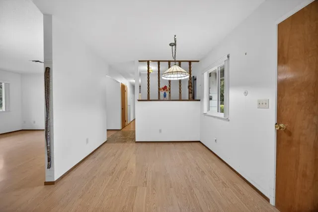 an empty room with a fireplace and wooden floor