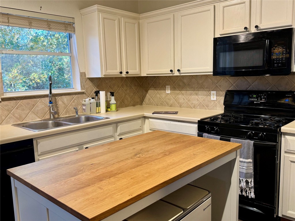 2308 Sweet Clover Drive Austin, TX 78745 - Photo 11 of 30 a kitchen with stainless steel appliances a stove a microwave and cabinets