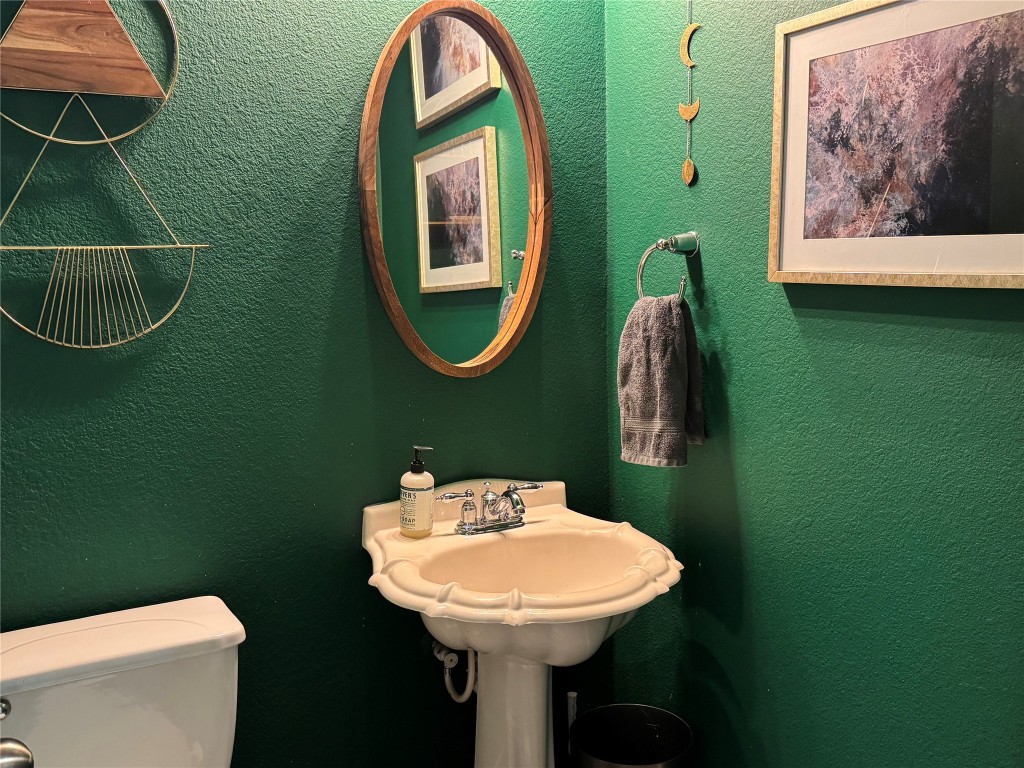 2308 Sweet Clover Drive Austin, TX 78745 - Photo 14 of 30 a bathroom with a toilet sink and mirror