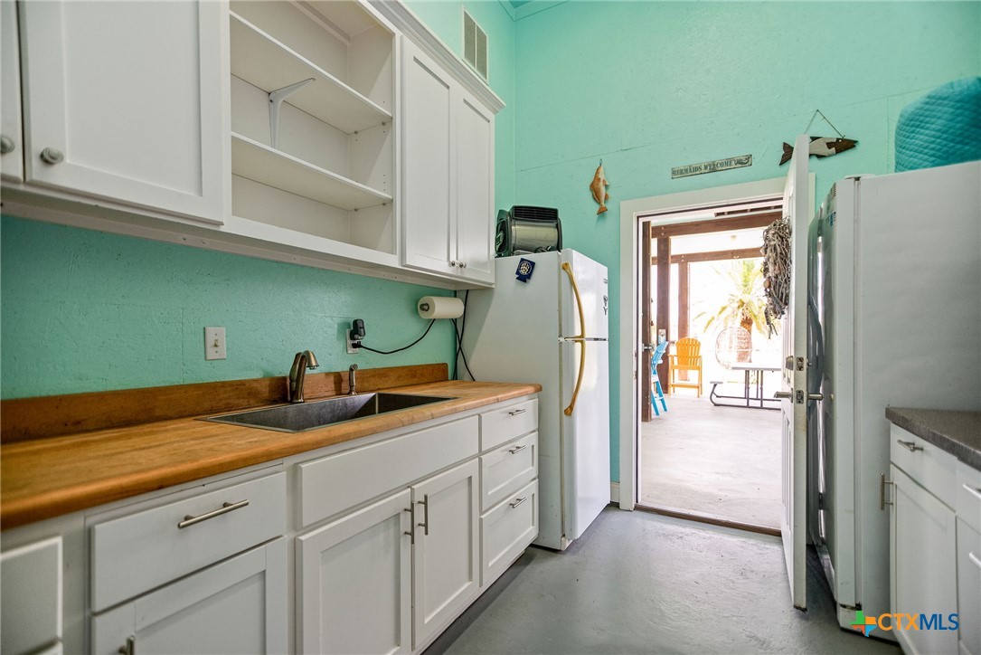 23 Macey Street Port O'Connor, TX 77982 - Photo 14 of 47 a utility room with cabinets washer and dryer