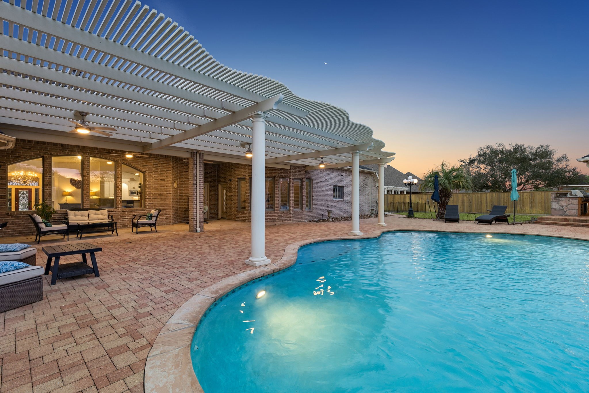 2202 Britton Ridge Drive Katy, TX 77494 - Photo 35 of 41 A true resort-style backyard retreat, featuring a sparkling pool and spa, expansive paver patio, and a dramatic pergola-covered entertaining area—perfect for evenings outdoors in the privacy of the guard-gated Lake Pointe Estates community. Designed for hosting at scale, this space sets the tone for luxury living on nearly an acre in Katy, Texas.