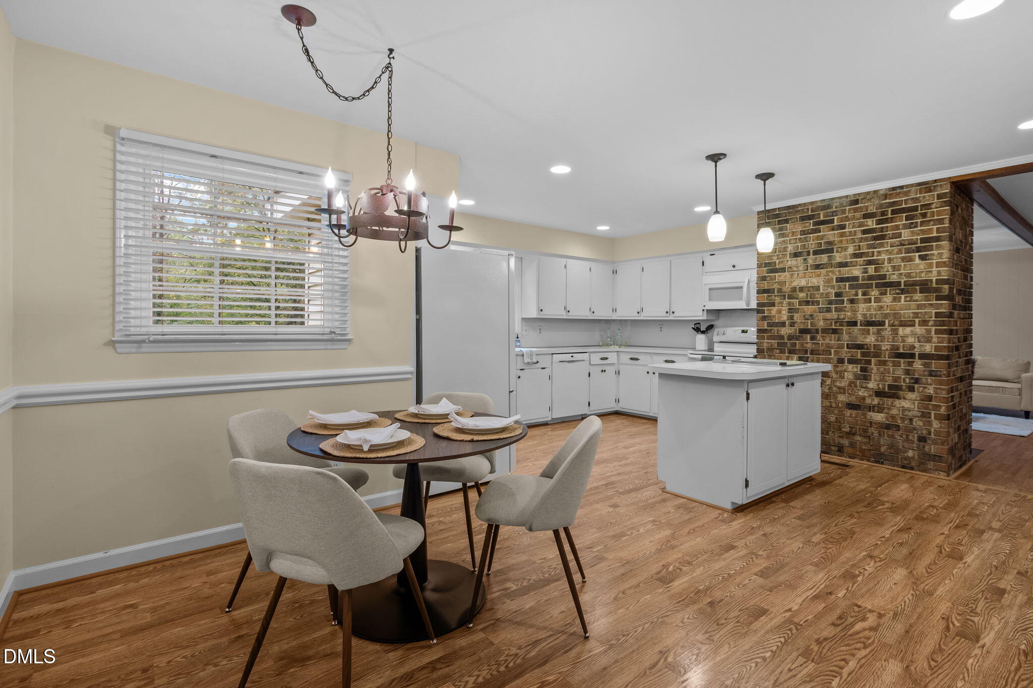 7105 Guess Road Hillsborough, NC 27278 - Photo 17 of 47 a kitchen with kitchen island a dining table chairs and white cabinets