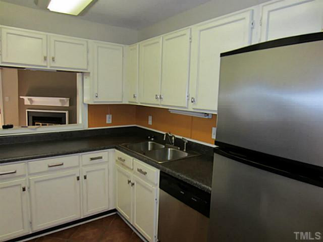 4110 Sedgewood Drive, Unit 302 Raleigh, NC 27612 - Photo 3 of 3 a kitchen with granite countertop white cabinets and black appliances