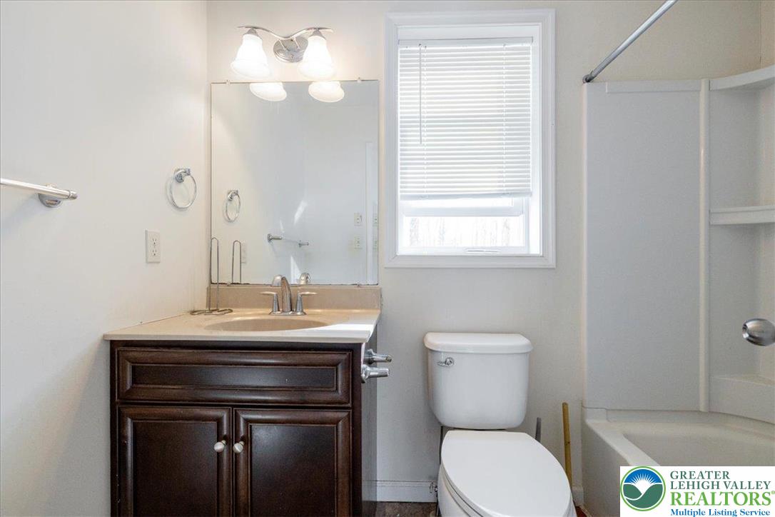 209 Buck Road East Stroudsburg, PA 18302 - Photo 17 of 25 a bathroom with a toilet a sink and mirror