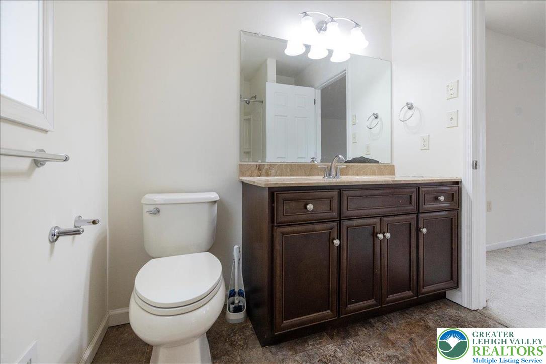 209 Buck Road East Stroudsburg, PA 18302 - Photo 20 of 25 a bathroom with a granite countertop toilet a sink and a mirror