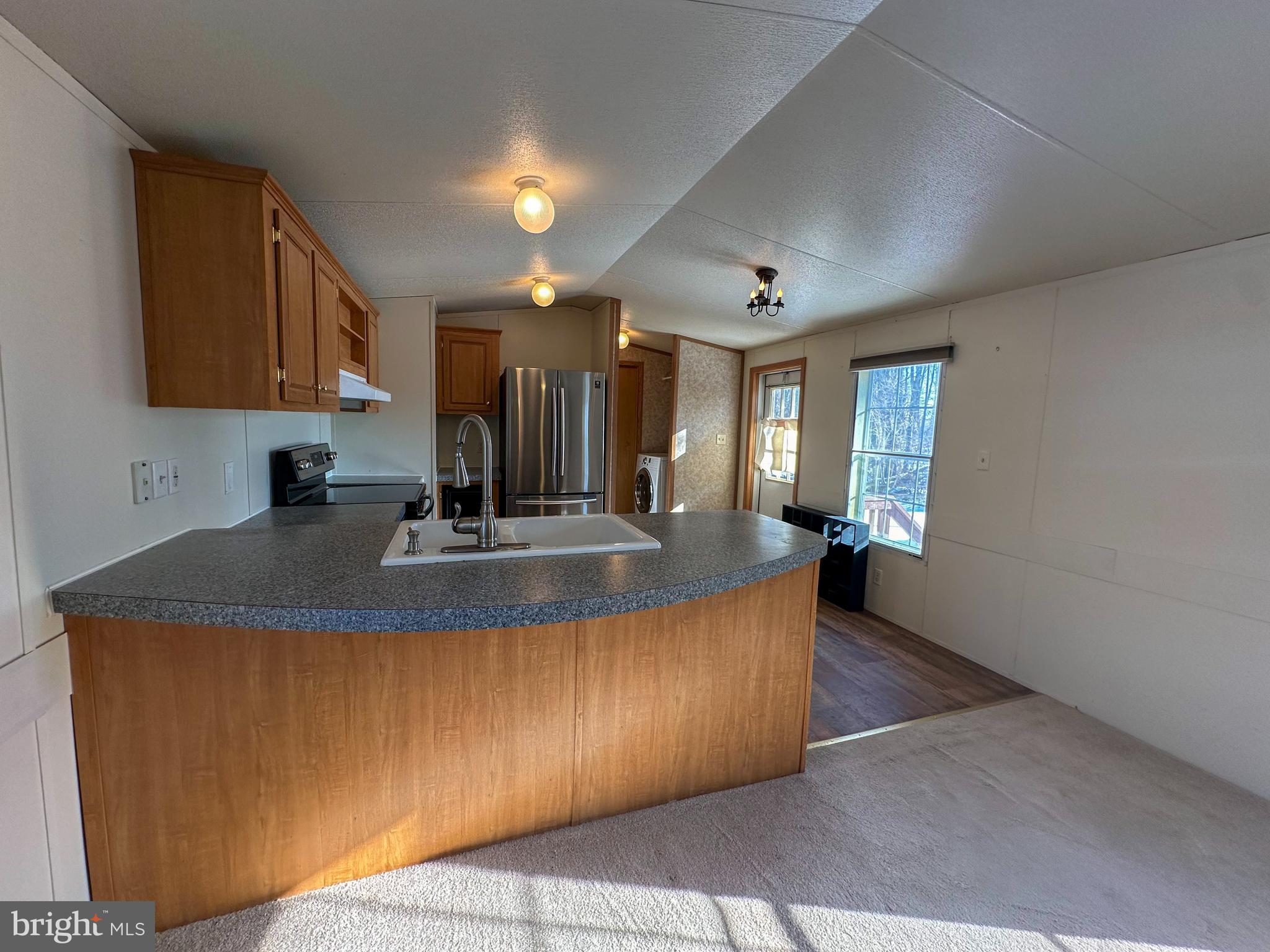 760 Azalea Lane Gap, PA 17527 - Photo 17 of 32 a view of a kitchen with kitchen island a sink granite counter tops and a view of living room