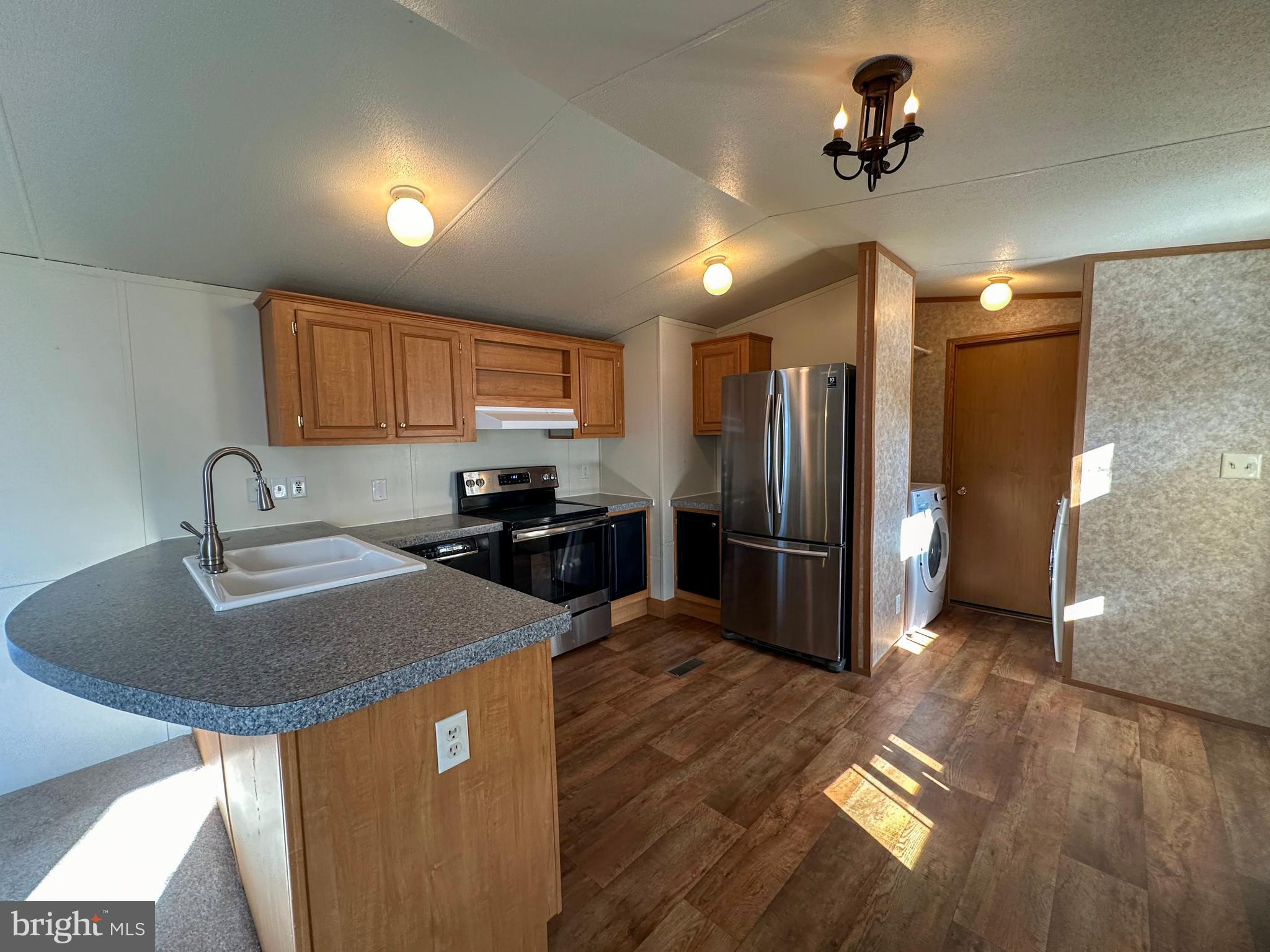 760 Azalea Lane Gap, PA 17527 - Photo 18 of 32 a kitchen with stainless steel appliances granite countertop a sink a stove a refrigerator cabinets and wooden floor