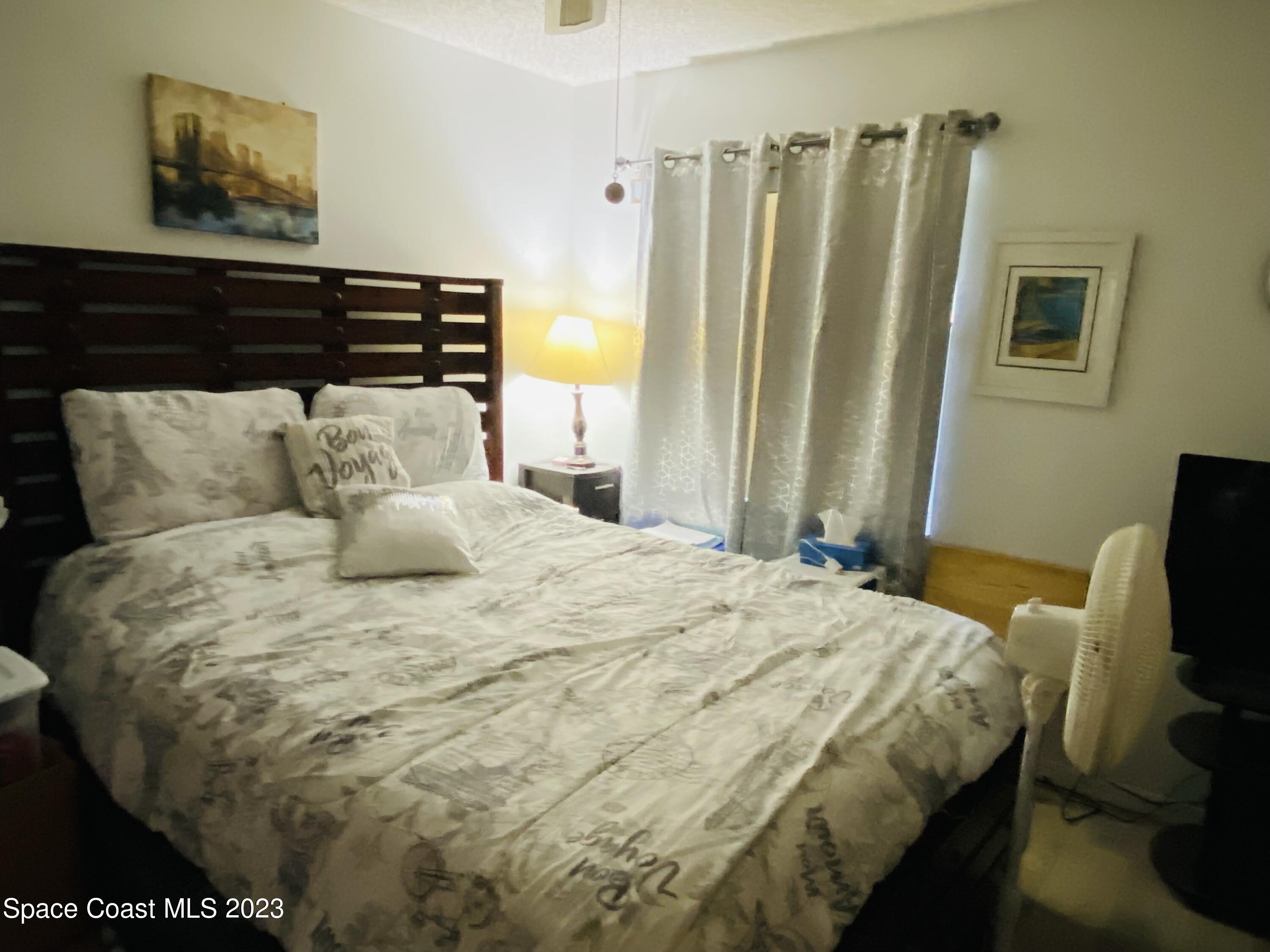 3985 Bayberry Drive Melbourne, FL 32901 - Photo 11 of 13 a bedroom with a bed and wooden floor