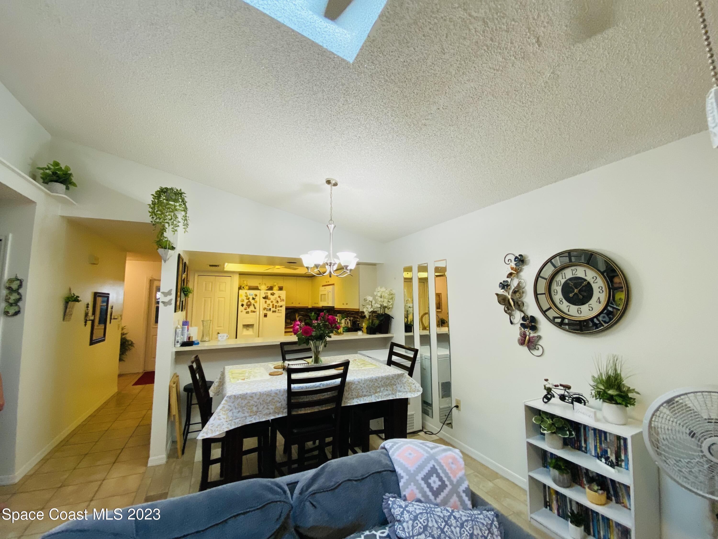 3985 Bayberry Drive Melbourne, FL 32901 - Photo 6 of 13 a living room with furniture and a clock