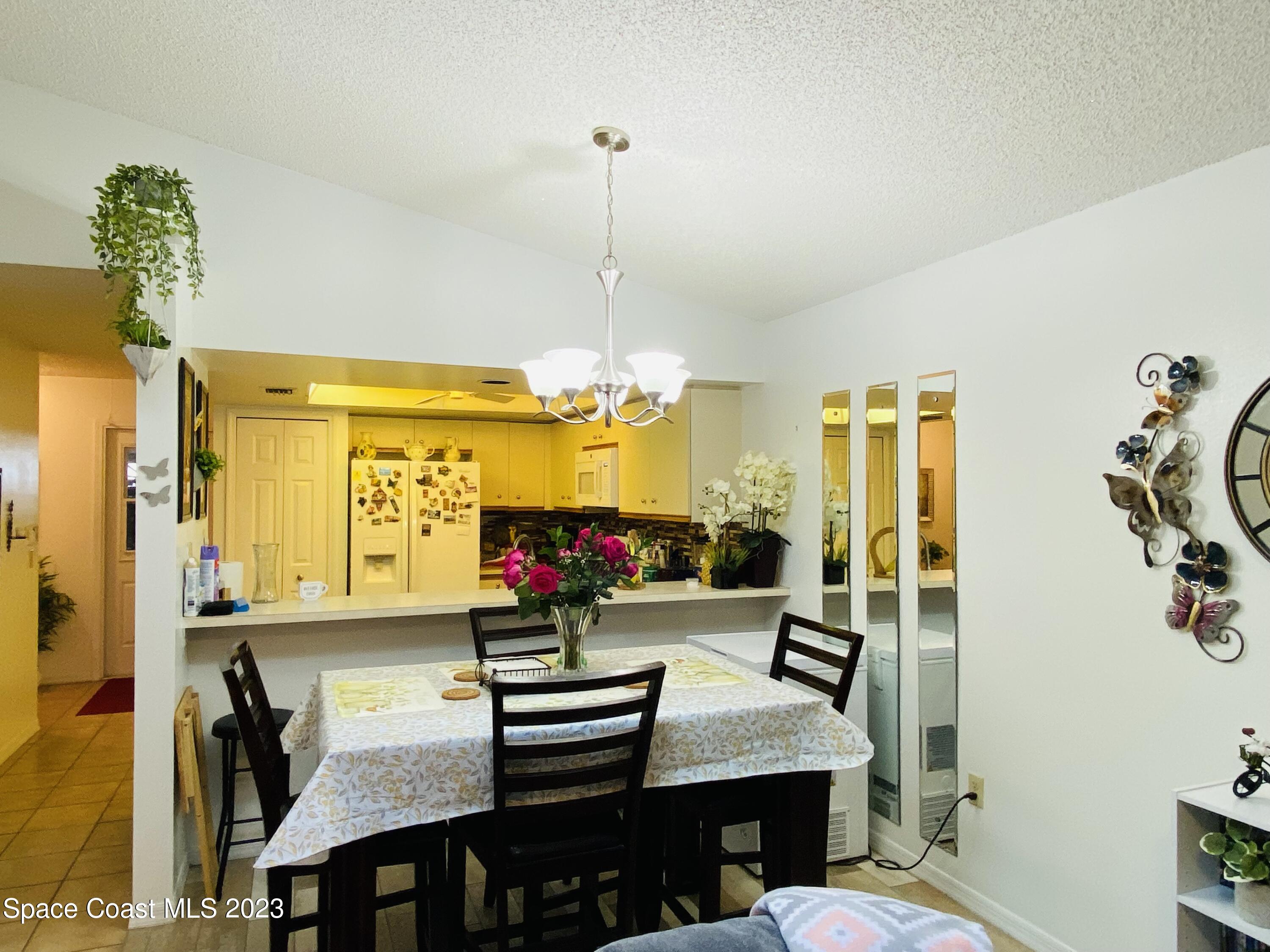 3985 Bayberry Drive Melbourne, FL 32901 - Photo 7 of 13 a view of a dining room with furniture and a chandelier