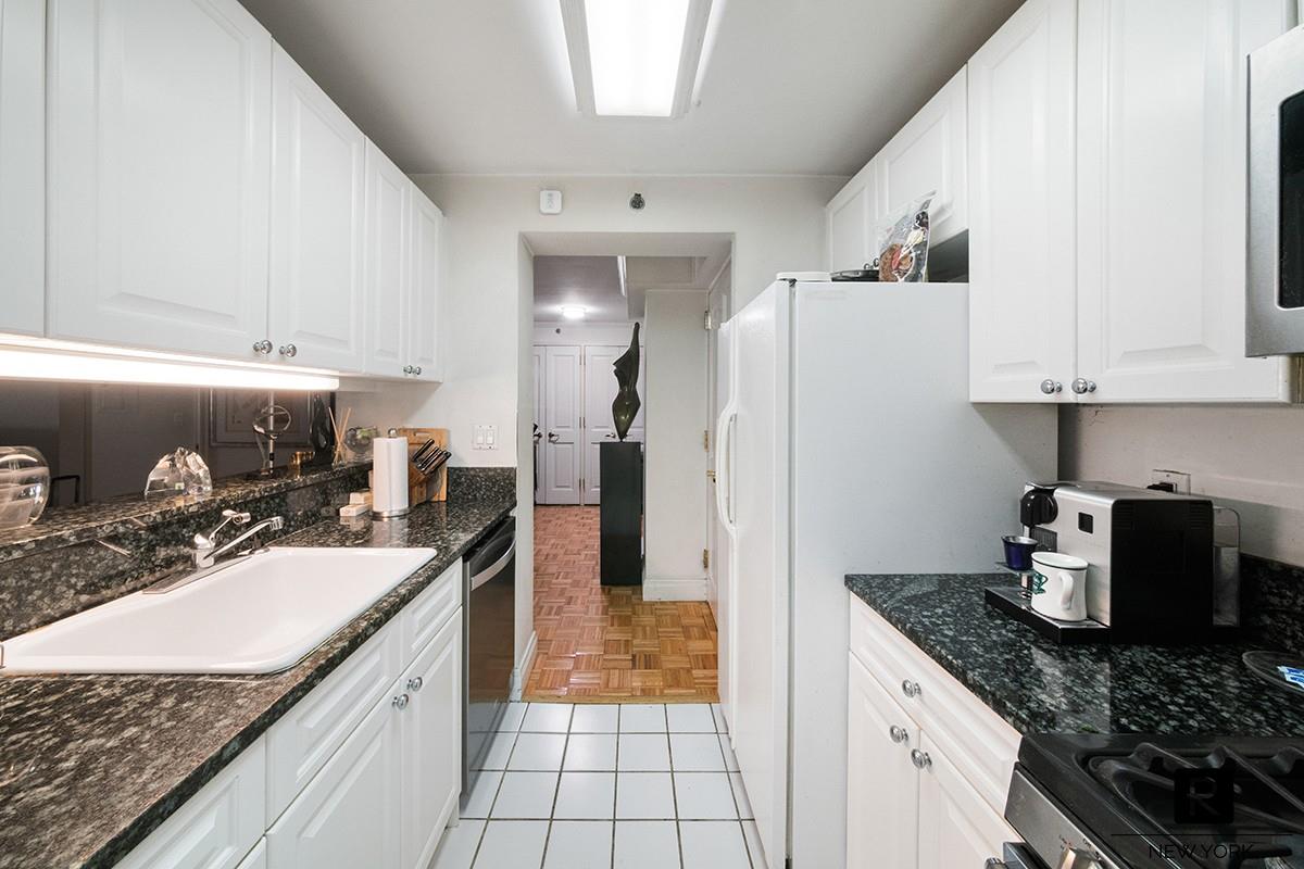 404 East 76th Street, Unit 3C Manhattan, NY 10021 - Photo 6 of 11 a kitchen with a sink a refrigerator and a stove