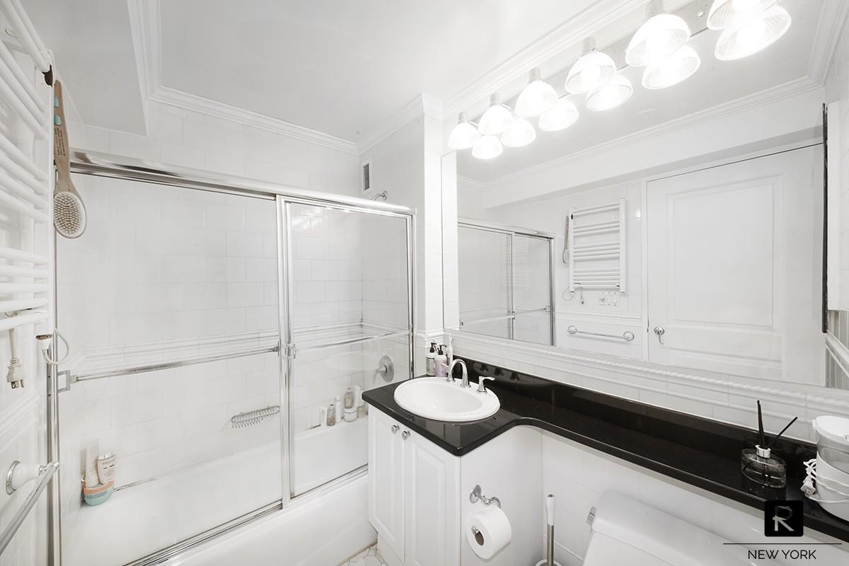 404 East 76th Street, Unit 3C Manhattan, NY 10021 - Photo 7 of 11 a bathroom with a sink and a mirror