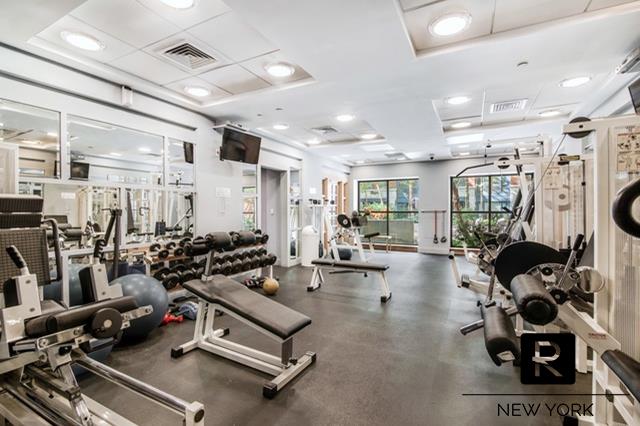 404 East 76th Street, Unit 3C Manhattan, NY 10021 - Photo 9 of 11 a room with gym equipment and a view of living room